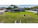 Expansive backyard with lush lawn, fire pit, screened patio, and storage shed at 2027 Fentress Ct, Spring Hill, FL 34609