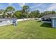 Expansive backyard featuring lush grass, a playset, large storage shed, and white privacy fence at 2027 Fentress Ct, Spring Hill, FL 34609