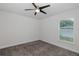 This is a minimalistic bedroom featuring carpet flooring and a ceiling fan, providing a quiet and comfortable space at 2027 Fentress Ct, Spring Hill, FL 34609