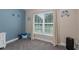 Cozy bedroom corner with a view, featuring beach-themed decor, a window, and gray carpeting at 2027 Fentress Ct, Spring Hill, FL 34609