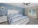 Nautical-themed bedroom with a white bed frame, blue accent wall, and plenty of natural light from the window at 2027 Fentress Ct, Spring Hill, FL 34609
