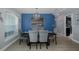 Dining room featuring a blue accent wall, gray chairs, and a dark table with a bridge painting at 2027 Fentress Ct, Spring Hill, FL 34609