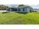 Exterior view showcasing the screened patio and lush green yard, surrounded by a white privacy fence at 2027 Fentress Ct, Spring Hill, FL 34609