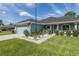 Close up of a lovely home featuring a well-manicured lawn, concrete driveway, and stylish light blue exterior at 2027 Fentress Ct, Spring Hill, FL 34609