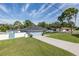 Lovely single-story home showcasing a long driveway, lush green lawn, and vibrant light blue exterior at 2027 Fentress Ct, Spring Hill, FL 34609