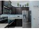 Modern kitchen featuring stainless steel appliances, granite countertops, and dark wood cabinets at 2027 Fentress Ct, Spring Hill, FL 34609