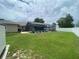 Backyard showing the pool, screened lanai, grassy area, and privacy fence at 3128 Montague Ave, Spring Hill, FL 34608