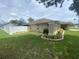 Green backyard with a white vinyl fence, tidy landscaping with stone edging, and mature trees at 3128 Montague Ave, Spring Hill, FL 34608