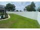 Green backyard with a white privacy fence and some landscaping at 3128 Montague Ave, Spring Hill, FL 34608