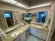 Bright bathroom featuring dual sinks, granite counters, a large mirror, and ample cabinet space at 3128 Montague Ave, Spring Hill, FL 34608