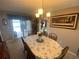 Inviting dining area with floral tablecloth, chandelier lighting and sliding doors leading to a patio at 3128 Montague Ave, Spring Hill, FL 34608