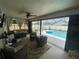 The lanai offers cozy seating and a serene view of the screened-in pool and yard at 3128 Montague Ave, Spring Hill, FL 34608