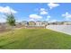 A wide shot of the backyard with lush greenery, enhanced by a white fence, ensuring privacy and a secure outdoor space at 313 Argyll Dr, Spring Hill, FL 34609