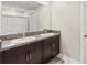 Bathroom with a double sink vanity, granite countertops, and dark wood cabinets at 313 Argyll Dr, Spring Hill, FL 34609
