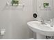 Half bath featuring a pedestal sink, round mirror, and modern fixtures at 313 Argyll Dr, Spring Hill, FL 34609