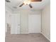 The bedroom has a ceiling fan, closet with double doors, and view into a hallway at 313 Argyll Dr, Spring Hill, FL 34609