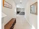 Inviting hallway featuring neutral tile flooring, a shoe bench, and a view into the living area at 313 Argyll Dr, Spring Hill, FL 34609