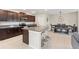 Spacious open-concept kitchen boasts dark cabinets, granite counters, a large island, and a dining area for easy entertaining at 313 Argyll Dr, Spring Hill, FL 34609