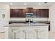 Beautiful kitchen with dark cabinets, granite countertops, an island with seating, and stainless steel appliances at 313 Argyll Dr, Spring Hill, FL 34609