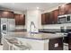 A modern kitchen featuring granite countertops, stainless steel appliances, and a large island with barstool seating at 313 Argyll Dr, Spring Hill, FL 34609