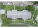 An aerial view of the condo building shows its layout, greenery, parking, and proximity to the lake at 3153 Lake Pine Way # A1, Tarpon Springs, FL 34688