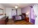 Cozy bedroom with wood laminate flooring, ceiling fan, and lilac accent wall at 3153 Lake Pine Way # A1, Tarpon Springs, FL 34688