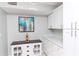 Charming butler's pantry with white cabinetry, a wine rack, and decorative artwork at 3153 Lake Pine Way # A1, Tarpon Springs, FL 34688