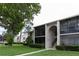 A beautiful condo exterior features a screen patio, landscaping, and well-maintained facade at 3153 Lake Pine Way # A1, Tarpon Springs, FL 34688