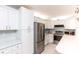 Updated kitchen with white cabinets, stainless steel appliances, and tile backsplash at 3153 Lake Pine Way # A1, Tarpon Springs, FL 34688
