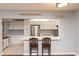 Bright kitchen features white cabinetry, stainless appliances, and a breakfast bar at 3153 Lake Pine Way # A1, Tarpon Springs, FL 34688