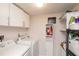 Functional laundry room with washer, dryer, storage cabinets, and shelving at 3153 Lake Pine Way # A1, Tarpon Springs, FL 34688