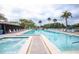 Community swimming pool and hot tub surrounded by lounge chairs and tropical palm trees at 3153 Lake Pine Way # A1, Tarpon Springs, FL 34688