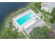 A community pool is surrounded by lounge chairs and lush landscaping near the lake at 3153 Lake Pine Way # A1, Tarpon Springs, FL 34688