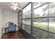 Enclosed lanai with glass windows and tile flooring, set up as an office space at 3153 Lake Pine Way # A1, Tarpon Springs, FL 34688