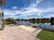 A brick-paved backyard offers waterfront views with a small boat dock for easy lake access at 3342 Turks Cap Dr, Hernando Beach, FL 34607