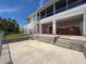 Backyard showing covered patio area with jacuzzi, stairs to second level, and brick-paved patio space at 3342 Turks Cap Dr, Hernando Beach, FL 34607