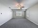 View of the airy bedroom featuring a ceiling fan, neutral walls, and carpet flooring and a large window at 3342 Turks Cap Dr, Hernando Beach, FL 34607