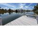 A private wooden dock on a canal showcases a serene view of the surrounding landscape and homes at 3342 Turks Cap Dr, Hernando Beach, FL 34607