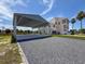 Charming two-story home with a covered parking area and landscaped front yard under a sunny sky at 3342 Turks Cap Dr, Hernando Beach, FL 34607