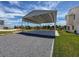 A spacious, covered parking area beside home with canal view and manicured lawn at 3342 Turks Cap Dr, Hernando Beach, FL 34607