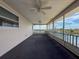 Enclosed outdoor carpeted patio with ceiling fans and views of the water at 3342 Turks Cap Dr, Hernando Beach, FL 34607