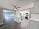 Bright, open kitchen featuring white cabinets, stainless steel appliances, and gray wood flooring at 3545 Landale Dr, Holiday, FL 34691