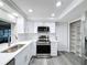 Bright kitchen with stainless steel appliances and white cabinetry with crown molding at 3545 Landale Dr, Holiday, FL 34691