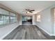 Bright sunroom featuring gray wood floors, many large windows and a ceiling fan at 3545 Landale Dr, Holiday, FL 34691