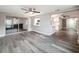 Living room featuring gray wood floors and view into kitchen with breakfast bar and stainless steel appliances at 3545 Landale Dr, Holiday, FL 34691