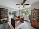 Bright office space featuring grey floors, a fan, and a large window overlooking tropical landscaping at 3545 Landale Dr, Holiday, FL 34691
