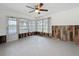 The sunroom has rustic wood paneling on the bottom half of the walls and a ceiling fan at 3545 Landale Dr, Holiday, FL 34691