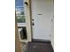 Entrance to the condo unit with the door, exterior light fixture, and window air conditioning unit at 4743 Jasper Dr # 107, New Port Richey, FL 34652
