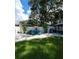 Spacious backyard featuring outdoor seating, a barbecue area, lush green grass, and mature trees at 5710 Broadway Ave, New Port Richey, FL 34652