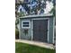 Backyard shed with gray double doors, adjacent to a green yard, adding utility and charm at 5710 Broadway Ave, New Port Richey, FL 34652